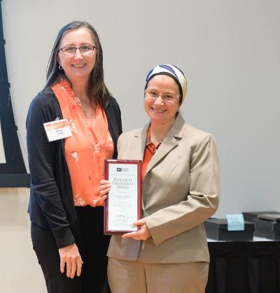 Dr. Gadalla celebrates with her longtime mentor and collaborator, IRP senior investigator Sharon Savage, after Dr. Gadalla received the Research Highlight Award at the 2022 National Cancer Institute Scientific Investigators Retreat